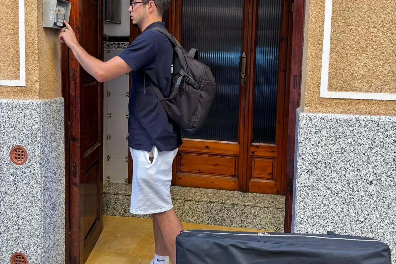 Fisioterapeuta de FisioAuris llamando al timbre de un domicilio del Maresme, con la camilla plegada en el suelo